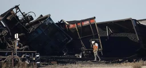 Workers toil to clear rail cars that derailed and collapsed a bridge over Interstate 25 northbound, Monday, Oct. 16, 2023, north of Pueblo, Colo. Federal investigators said Thursday they’re looking at BNSF Railway’s inspection and maintenance practices as the investigate the accident that killed a truck driver passing beneath the train. (AP Photo/David Zalubowski, File)