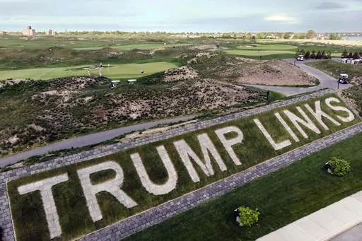FILE — Patrons play the links as a giant branding sign is displayed with flagstones at Trump Golf Links, at Ferry Point in the Bronx borough of New York, May 4, 2021. The Trump Organization has sold its right to operate a public golf course in the Bronx, city officials confirmed, Friday, Sept. 8, 2023, offloading control of the city-owned property to a company that is seeking to build a casino in New York City. (AP Photo/John Minchillo, File)