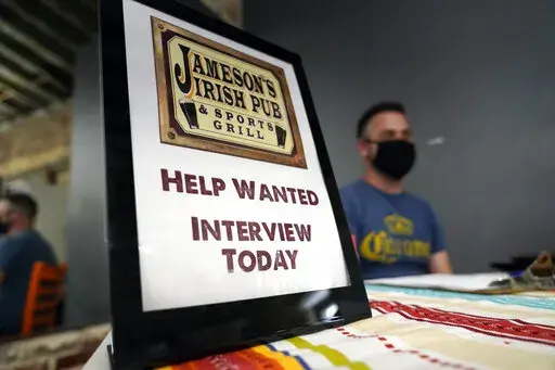 A hiring sign is placed at a booth for Jameson's Irish Pub during a job fair Wednesday, Sept. 22, 2021, in the West Hollywood section of Los Angeles.  In a surprising burst of hiring, America’s employers added 467,000 jobs in January 2022 in a sign of the economy’s resilience even in the face of a wave of omicron infections last month. (AP Photo/Marcio Jose Sanchez, File)
