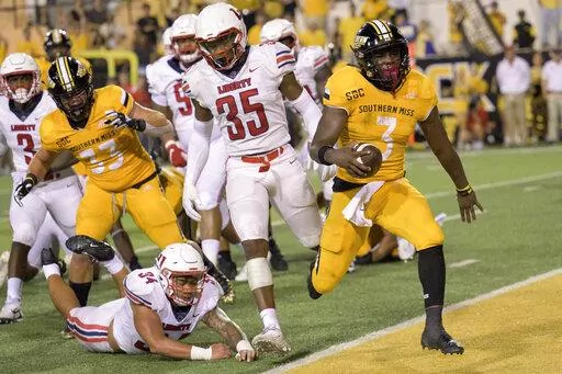 Southern Miss running back Frank Gore Jr. (3) scores while filling in as quarterback against Liberty linebacker Ahmad Walker (34) dives after him during the second half of an NCAA football game on Friday, Sept. 3, 2022, in Hattiesburg, Miss. The son of one of the NFL’s most prolific running backs made quite a name for himself this bowl season. (AP Photo/Matthew Hinton, File)