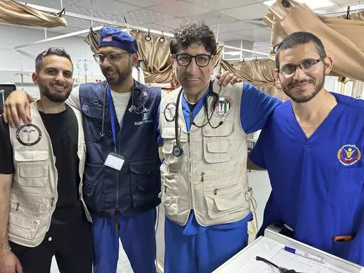 Dr. Ammar Ghanem, an ICU specialist from Detroit volunteering with the Syrian American Medical Society at one of Gaza's last functioning hospitals, second from right, poses on May 7, 2024, in Khan Younis, Gaza, with a Palestinian doctor and two other American doctors volunteering at the European General Hospital where they have been since early May. A group of 35 foreign doctors on a volunteer mission to help at the hospital, including 22 Americans, have been trapped in Gaza by Israel’s seizur