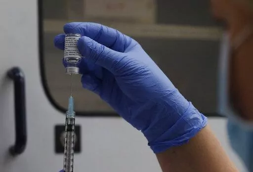 A vial of the Phase 3 Novavax coronavirus vaccine is seen ready for use in the trial at St. George's University hospital in London, Oct. 7, 2020. The Novavax COVID-19 vaccine that could soon win federal approval may offer a boost for the U.S. military: an opportunity to get shots into some of the thousands of service members who have refused the vaccine for religious reasons. (AP Photo/Alastair Grant, File)