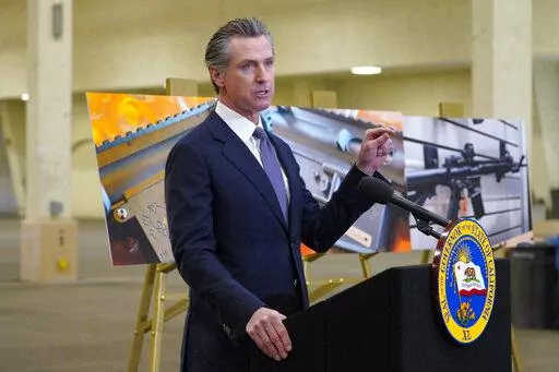 California Gov. Gavin Newsom, along with several elected officials, meets with the media at Del Mar Fairgrounds on Friday, Feb. 18, 2022, in Del Mar, Calif., where he backed state legislation that would allow for private citizens to enforce the state's ban on assault weapons. A U.S. appeals court ruled Wednesday, May 11 that California’s ban on the sale of semiautomatic weapons to adults under 21 is unconstitutional.  (Nelvin C. Cepeda/The San Diego Union-Tribune via AP, File)