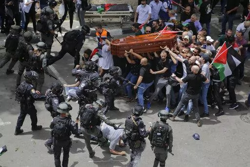 Israeli police confront with mourners as they carry the casket of slain Al Jazeera veteran journalist Shireen Abu Akleh during her funeral in east Jerusalem, Friday, May 13, 2022. Abu Akleh, a Palestinian-American reporter who covered the Mideast conflict for more than 25 years, was shot dead Wednesday during an Israeli military raid in the West Bank town of Jenin. (AP Photo/Maya Levin)