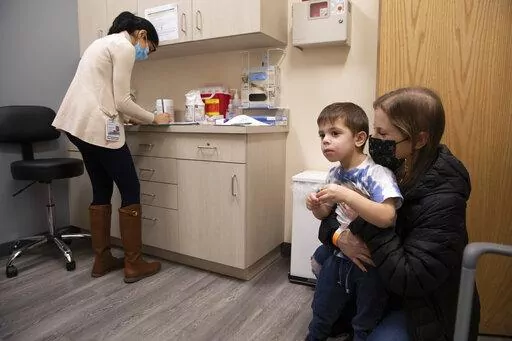 Ilana Diener holds her son, Hudson, 3, during an appointment for a Moderna COVID-19 vaccine trial in Commack, N.Y. on Nov. 30, 2021. Parents hoping to get their youngest children vaccinated against COVID-19 have some encouraging news. Pfizer said Monday, May 23, 2022, that three doses of its vaccines offers strong protection to those under 5. That news comes a month after Moderna said it would ask regulators to OK its two shot regimen for the youngest kids. (AP Photo/Emma H. Tobin, File)
