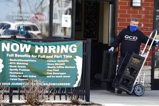 A hiring sign is displayed outside of a Starbucks in Schaumburg, Ill., Friday, April 1, 2022.  The number of Americans applying for jobless aid ticked up slightly last week but the total number of Americans collecting benefits remained at its lowest level in more than five decades. Applications for unemployment benefits rose by 1,000 to 203,000 for the week ending May 7, the Labor Department reported Thursday, May 12.  (AP Photo/Nam Y. Huh)