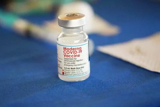 A vial of Moderna COVID-19 vaccine rests on a table at an inoculation station next to Jackson State University in Jackson, Miss., on July 19, 2022. British health authorities have authorized an updated version of Moderna's coronavirus vaccine that aims to protect against the original virus and the omicron variant. (AP Photo/Rogelio V. Solis)