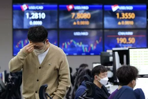 A currency trader holds his head at the foreign exchange dealing room of the KEB Hana Bank headquarters in Seoul, South Korea, Friday, Feb. 25, 2022. Asian shares rose Friday after U.S. stocks recovered toward the end of a wild trading day, as the world, including President Joe Biden, slapped sanctions against Russia for its invasion of Ukraine. (AP Photo/Ahn Young-joon)