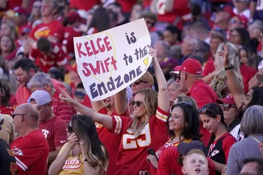 A fan holds a sign during the first half of an NFL football game between the Chicago Bears and Kansas City Chiefs Sunday, Sept. 24, 2023, in Kansas City, Mo. Eager as the National Football League has been to cater to the recent public fixation with Taylor Swift and Travis Kelce, it’s certainly not taking any credit for creating the "situationship" between the pop superstar and the Kansas City Chiefs tight end.(AP Photo/Ed Zurga, File)