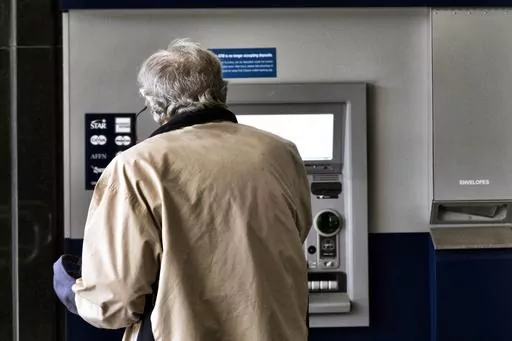 A customer makes a transaction at an automatic teller machine in Los Angeles on March 27, 2023. The cost to overdraw a bank account could drop to as little as $3 under a proposal announced by the White House, the latest move by the Biden administration to combat fees it says pose an unnecessary burden on American consumers, particularly those living paycheck to paycheck. (AP Photo/Richard Vogel, File)