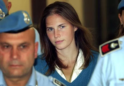 In this Sept. 26, 2008 Amanda Knox, center, is escorted by Italian penitentiary police officers to Perugia's court. Amanda Knox faces yet another trial for slander in a case that could remove the last remaining guilty verdict against her nine years after Italy's highest court definitively threw out her conviction for the murder of her 21-year-old British roommate, Meredith Kercher. (AP Photo/Pier Paolo Cito, File)
