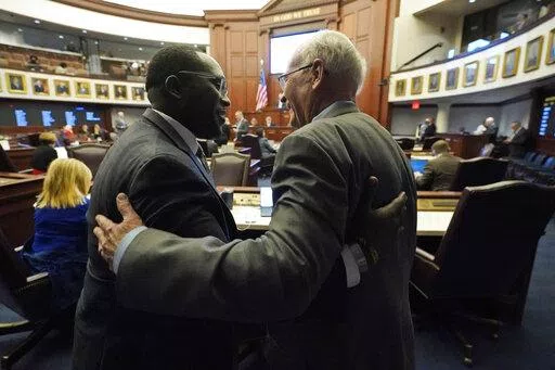Florida Sen. Dennis Baxley, right, the sponsor of a bill, dubbed by opponents as the "Don't Say Gay" bill, hugs an opponent of the bill, Sen. Shevrin Jones, after the bill passed during a legislative session at the Florida State Capitol, Tuesday, March 8, 2022, in Tallahassee, Fla. (AP Photo/Wilfredo Lee)