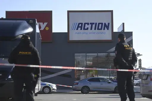 Police officers stand guard in a shopping area in Hradec Kralove, Czech Republic, at the site where two women have died in a knife attack, Thursday, Feb 20, 2025. (Josef Costarek/CTK via AP)