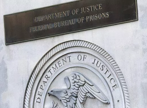 A sign for the Department of Justice Federal Bureau of Prisons is displayed at the Metropolitan Detention Center in the Brooklyn borough of New York,  July 6, 2020. The Justice Department has settled a long-running lawsuit filed by a group of men rounded up in the weeks after the September 2001 attack who say they were abused in a federal lockup in New York City. (AP Photo/Mark Lennihan, File)