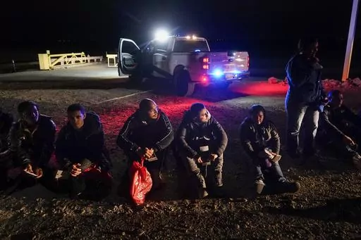 Migrants wait to be processed after crossing the border, Jan. 6, 2023, near Yuma, Ariz. A federal judge on Tuesday, July 25, blocked a rule that allows immigration authorities to deny asylum to migrants who arrive at the U.S.-Mexico border without first applying online or seeking protection in a country they passed through. But the judge delayed his ruling from taking effect immediately to give the administration time to appeal. (AP Photo/Gregory Bull, File)