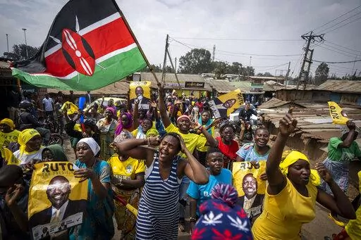 Supporters of William Ruto hold campaign posters of him and wave a national flag as they celebrate and march along a street in the Kibera neighborhood of Nairobi, Kenya Monday, Sept. 5, 2022. Kenya’s Supreme Court has unanimously rejected challenges to the official results of the presidential election and upheld Deputy President William Ruto’s narrow win in East Africa’s most stable democracy. Ruto is expected to be sworn in on Sept. 13. (AP Photo/Ben Curtis)