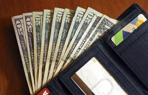 Cash is fanned out from a wallet in North Andover, Mass., June 15, 2018. Financial experts say by making steady progress toward your financial goals and aligning your spending with your values, you can feel richer regardless of how much money you actually have in your bank account. (AP Photo/Elise Amendola, File)