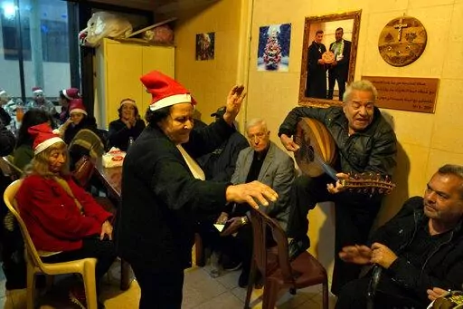 Amira Mansour, center, dances as Samir Damouni playing the Oud during community Christmas dinner for elderly residents at the only majority-Christian Palestinian refugee camp, in Dbayeh, north of Beirut, Lebanon, Wednesday, Dec. 21, 2022. Hundreds of thousands of Palestinians fled or were forced from their homes during the 1948 Mideast war over Israel's creation. Today, several million Palestinian refugees and their descendants are scattered across Jordan, Syria and Lebanon, as well as the West 