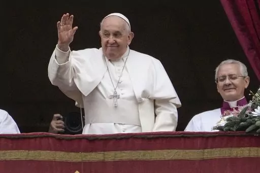 Pope Francis waves before delivering the Urbi et Orbi (Latin for 'to the city and to the world' ) Christmas' day blessing from the main balcony of St. Peter's Basilica at the Vatican, Monday Dec. 25, 2023. (AP Photo/Gregorio Borgia)