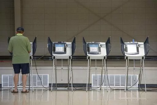 A voter uses an electronic voting machine to cast a ballot in the Mississippi primary election at a polling location in Jackson County, Miss., on June 7, 2022. Mississippi voters will be able to use their smartphones as voter identification in the November election, marking the first real test of a new statewide program that integrates technology into the voting process. (Hannah Ruhoff/The Sun Herald via AP, File)