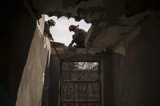 Firefighters work to secure a building previously damaged by a Russian attack in Kharkiv, Ukraine, Saturday, April 9, 2022. (AP Photo/Felipe Dana)