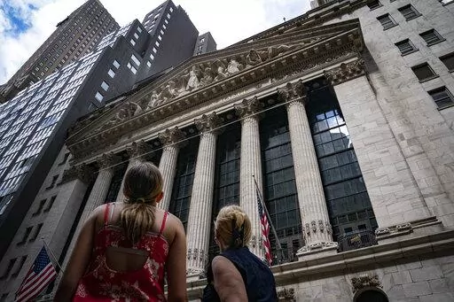Pedestrians pass the New York Stock Exchange on July 14, 2022, in New York. The U.S. economy is caught in an awkward, painful place. A confusing one, too. Growth appears to be sputtering, home sales are tumbling and economists warn of a potential recession ahead. But consumers keep spending, businesses keep posting profits and the economy keeps adding hundreds of thousands of jobs a month. (AP Photo/John Minchillo, File)