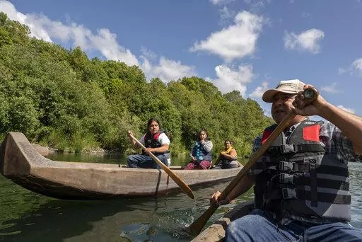 Yurok tribal members lead a redwood canoe tour on the lower Klamath River on Tuesday, June 8, 2021, in Klamath, Calif. California officials and tribal leaders announced the Visit Native California initiative to drive up tourism in Native communities, Wednesday, Sept. 14, 2022. The canoe tours, in traditionally-made canoes, are among the many cultural experiences visitors can find throughout the state. (AP Photo/Nathan Howard, File)