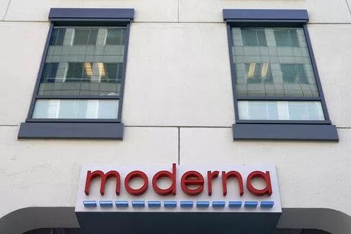 In this Dec. 15, 2020, file photo, a sign for Moderna, Inc. hangs on its headquarters in Cambridge, Mass.  Moderna's experimental COVID-19 vaccine that combines its original shot with protection against the omicron variant appears to work, the company announced Wednesday, June 8, 2022.  COVID-19 vaccine makers are studying updated boosters that might be offered in the fall to better protect people against future coronavirus surges.(AP Photo/Elise Amendola, File)