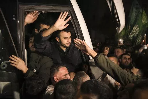 Men wave after being released from prison by Israel, Thursday, Nov. 30, 2023, in the West Bank town of Ramallah. (AP Photo/Nasser Nasser, File)