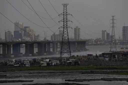 High tension power lines pass through Makoko slum in Lagos, Nigeria, Saturday, Aug. 20, 2022. From Zimbabwe, where many must work at night because i t's the only time there is power, to Nigeria where collapses of the grid are frequent, the reliable supply of electricity remains elusive across Africa. (AP Photo/Sunday Alamba/File)