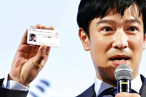Japanese actor Masato Sakai shows a sample of My Number card during a promotional event in Tokyo on March 8, 2021. Japan has stepped up its push to catch up on digitization by telling a reluctant public they have to sign up for digital IDs or possibly lose access to their public health insurance. (Kyodo News via AP)