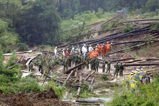 Rescuers conduct a search operation at the site of a landslide in Mimata, Miyazaki Prefecture, southern Japan, Monday Sept. 19, 2022. Powerful Typhoon Nanmadol slammed ashore in southern Japan on Sunday as it pounded the region with strong winds and heavy rain, causing blackouts, paralyzing ground and air transportation and prompting the evacuation of thousands of people. (Kyodo News via AP)