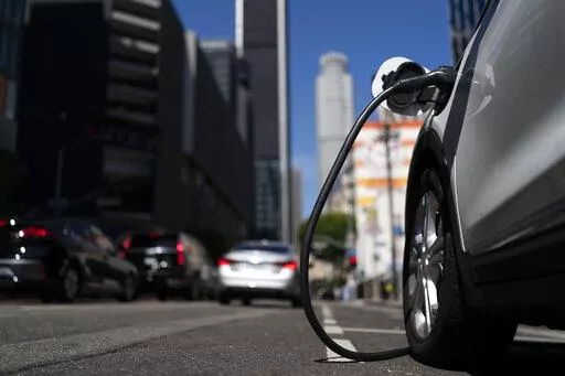 An electric vehicle is plugged into a charger in Los Angeles, Thursday, Aug. 25, 2022. California plans to require all new cars, trucks and SUVs to run on electricity or hydrogen by 2035 under a policy approved Thursday by regulators that seeks a dramatic cut in carbon emissions and an eventual end to gasoline-powered vehicles. (AP Photo/Jae C. Hong)