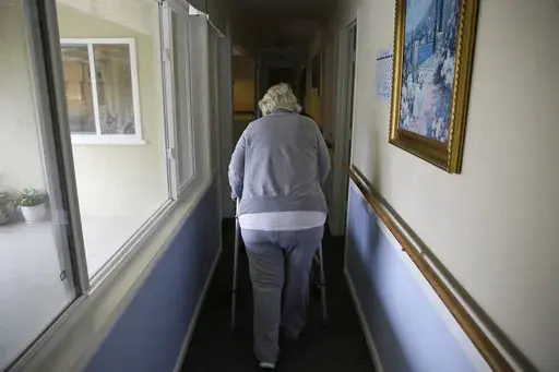 A woman walks to her room at a senior care home in Calistoga, Calif., on Dec. 5, 2019. (AP Photo/Eric Risberg, File)