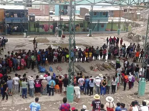 Residents stand around the bodies of persons who perished in recent landslides in Camana, Peru, Monday, Feb. 6, 2023. According to a preliminary report issued by Civil Defense, more than 30 people died as a consequence of non-stop heavy rains and landslides. (AP Photo/Ever Chambi)