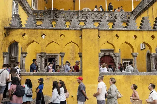 Tourists queue to visit the interior of the 19th century Pena Palace in Sintra, Portugal, Wednesday, Aug. 14, 2024. (AP Photo/Ana Brigida)