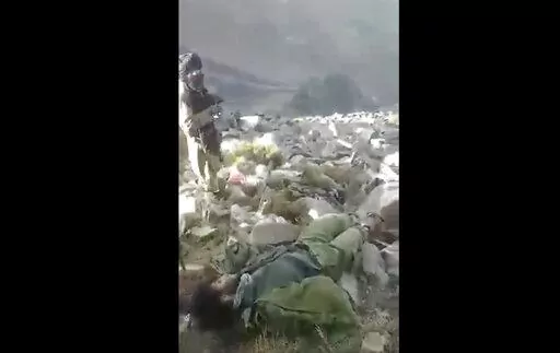 In this frame grab from video that was likely taken by the Taliban and posted online and provided by Afghan Witness, a UK-based open-source nonprofit, a Taliban fighter stands amid bodies on the ground, in the Dara district, of Panjshir province, Afghanistan, Sept. 14, 2022. The Taliban captured, bound and shot to death 27 men in Afghanistan’s Panjshir Valley last month during an offensive against resistance fighters in the area, according to a new report by Afghan Witness published Tuesday, O
