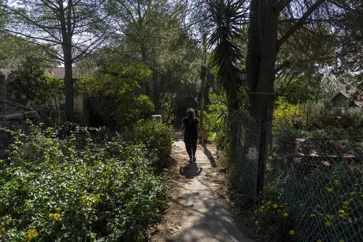 A woman walks in the tiny settlement of "Trump Heights" in the Israeli-controlled Golan Heights, where residents are welcoming the election of their namesake. They hope Donald Trump's return to the U.S. presidency will breathe new life into the community. Thursday, Nov. 7, 2024. (AP Photo/Ariel Schalit)