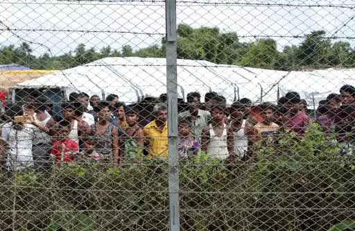 Rohingya refugees gather near a fence during a government organized media tour, to a no-man's land between Myanmar and Bangladesh, near Taungpyolatyar village, Maung Daw, northern Rakhine State, Myanmar, June 29, 2018. An international case accusing Myanmar of genocide against the Rohingya ethnic minority returns to the United Nations' highest court Monday, Feb. 21, 2022, amid questions over whether the country's military rulers should even be allowed to represent the Southeast Asian nation. (AP