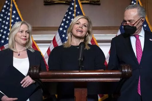 Former Fox News anchor Gretchen Carlson, center, celebrates with Sen. Kirsten Gillibrand, D-N.Y., left, and Senate Majority Leader Chuck Schumer, D-N.Y., after Congress gave final approval to legislation guaranteeing that people who experience sexual harassment at work can seek recourse in the courts, during a news conference at the Capitol in Washington, Thursday, Feb. 10, 2022. Since her 2016 sexual harassment lawsuit against then Fox News Chairman and CEO Roger Ailes, Carlson has worked to ba