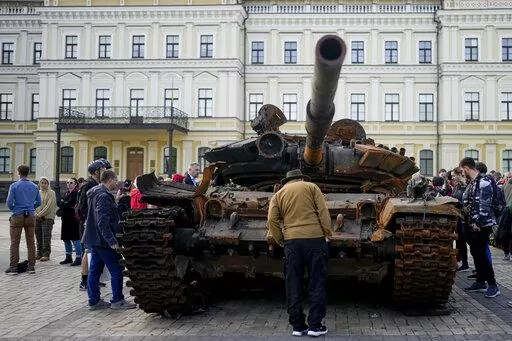 A man looks at a destroyed Russian tank placed as a symbol of war in downtown Kyiv, Ukraine, May 23, 2022. A new report from NewsGuard, a tech firm that tracks disinformation has identified 250 websites actively working to spread Kremlin disinformation.(AP Photo/Natacha Pisarenko, File)