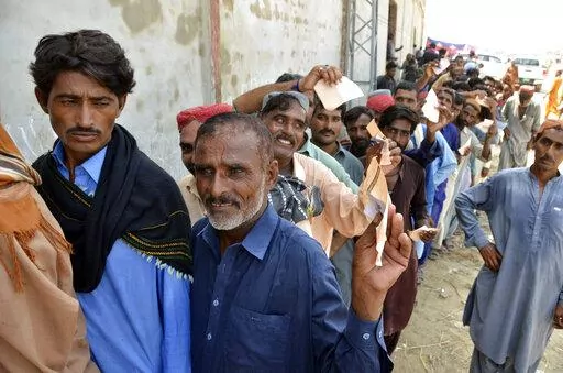 Displaced families, who fled their flood-hit homes, line up to get relief aid in Jaffarabad, a district of Baluchistan province, Pakistan, Wednesday, Sept. 21, 2022. Devastating floods in Pakistan's worst-hit province have killed 10 more people in the past day, including four children, officials said Wednesday as the U.N. children's agency renewed its appeal for $39 million to help the most vulnerable flood victims. (AP Photo/Zahid Hussain)