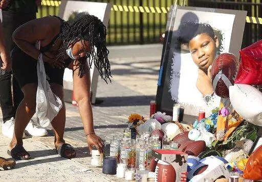 Family members and friends of Tyre Sampson leave items during a vigil in front of the Orlando Free Fall drop tower in ICON Park in Orlando on Monday, March 28, 2022. Sampson, 14, was killed when he fell from the ride late Thursday evening.  (Stephen M. Dowell/Orlando Sentinel via AP)