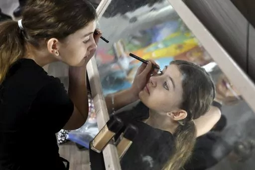 Erica Biggs puts on makeup before performing in “The Bullying Collection” at Wheatland High School in Wheatland, Wyoming on Friday, Jan. 12, 2024. School officials canceled the middle school play in part because it mentioned a gay character. The anti-bullying play was nonetheless performed under private sponsorship. (AP Photo/Thomas Peipert)