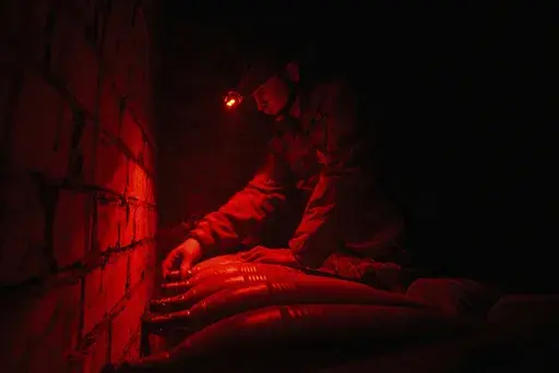 A Ukrainian serviceman of the Bugskiy Gard unit prepares a 120mm mortar before firing towards Russian positions on the front line, in the Kherson region, Ukraine, Sunday, Nov. 3, 2024. (AP Photo/Marko Ivkov)