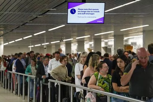 Travelers wait in long lines to check in and board flights at Amsterdam's Schiphol Airport, Netherlands, on June 21, 2022. Amsterdam’s Schiphol Airport has launched a compensation scheme for travelers who missed their flights because of lengthy delays that have plagued the busy European aviation hub for months. Schiphol announced the scheme Thursday night, Aug. 11, 2022, heading off a possible mass claim for compensation by passengers who saw their holiday plans evaporate amid hours-long delay