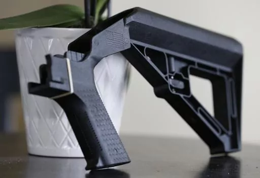 A bump stock is displayed in Harrisonburg, Va., on March 15, 2019. The Supreme Court will hear a challenge Wednesday, Feb. 28, to a Trump-era ban on bump stocks, a gun accessory used in a Las Vegas massacre that was the deadliest mass shooting in modern U.S. history. (AP Photo/Steve Helber, File)