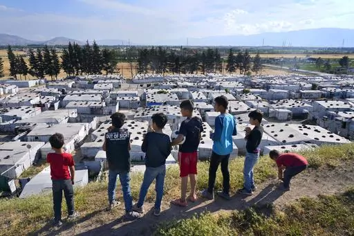 Syrian children stand on a hill above a refugee camp in the town of Bar Elias, in Lebanon's Bekaa Valley, Tuesday, June 13, 2023. Aid agencies are yet again struggling to draw the world's attention back to Syria in a two-day donor conference hosted by the European Union in Brussels for humanitarian aid to Syrians that begins Wednesday. Funding from the conference also goes toward providing aid to some 5.7 million Syrian refugees living in neighboring countries, particularly Turkey, Lebanon and J