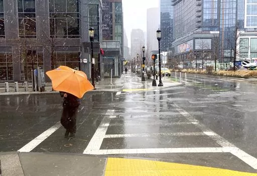 A person braces against the wind as a wintry mix of snow and rain falls in Boston, March 14, 2023. A winter weather system moving through the U.S. is expected to wallop the East Coast this weekend, Saturday, Jan. 6, 2024, into Sunday, Jan. 7, with a mix of snow and freezing rain from the southern Appalachians to the Northeast — although it's too early to say exactly which areas will get what precipitation and how much. (AP Photo/Michael Casey, File)