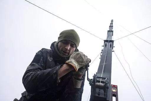 Ukrainian servicemen from 127 brigade prepare a telescopic tower with a remote camera installed on a Soviet car "Volga" that was recast to observe and correct fire on the front line near Kharkiv, Ukraine, Sunday, Dec. 25, 2022. (AP Photo/Evgeniy Maloletka)